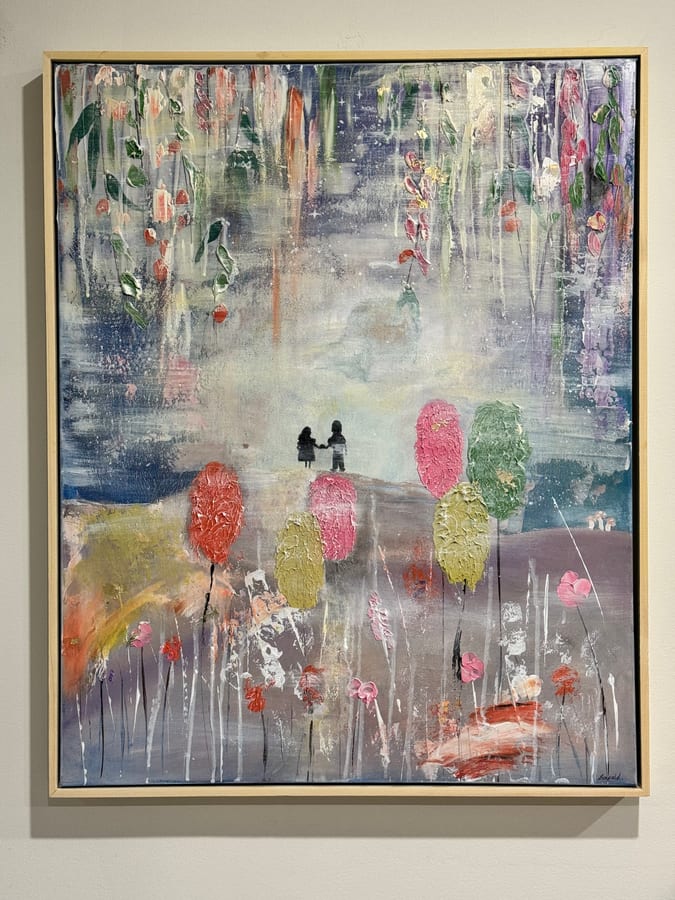 Framed landscape painting: two small figures on a hillside at dusk among soft blue and pink foliage.