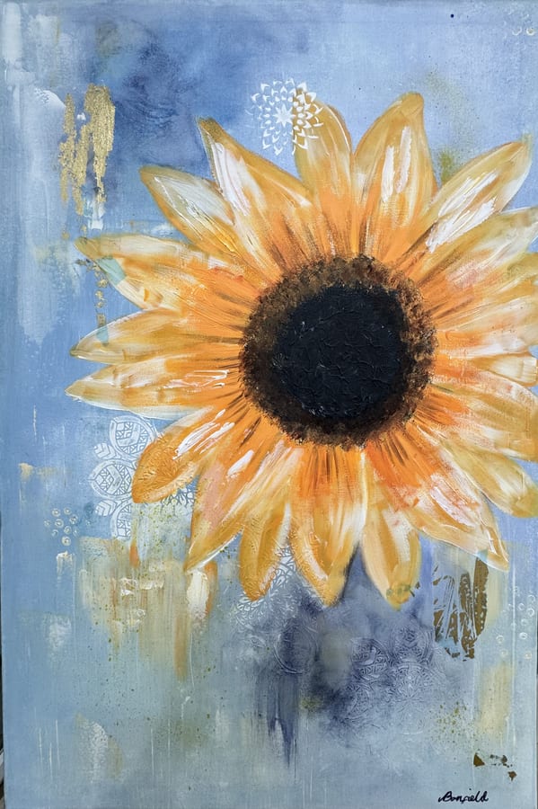 A single golden sunflower on a soft blue ground with pale lace texture behind.