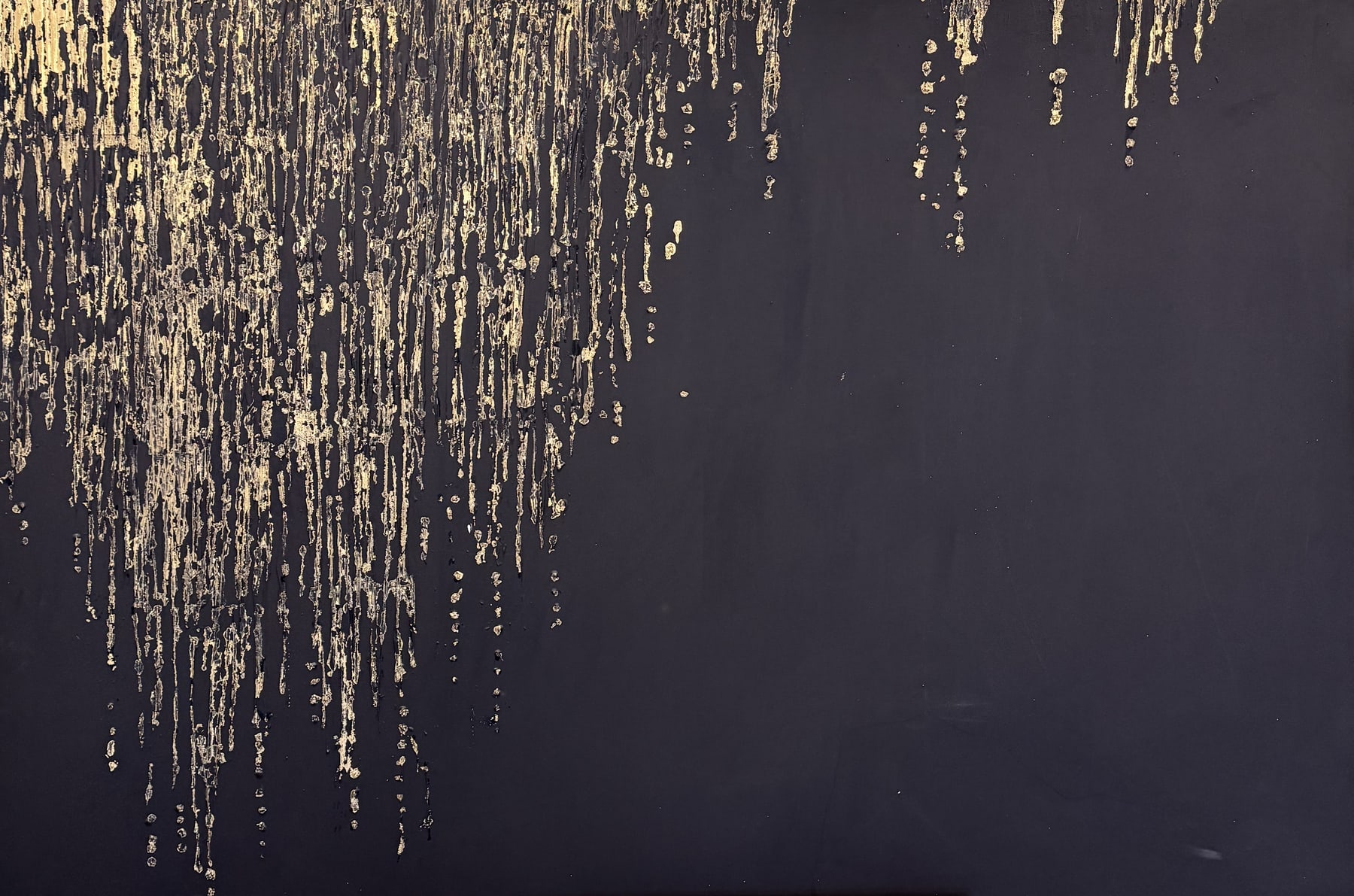 A deep black canvas with streams of gold foil drifting down from the top edge.